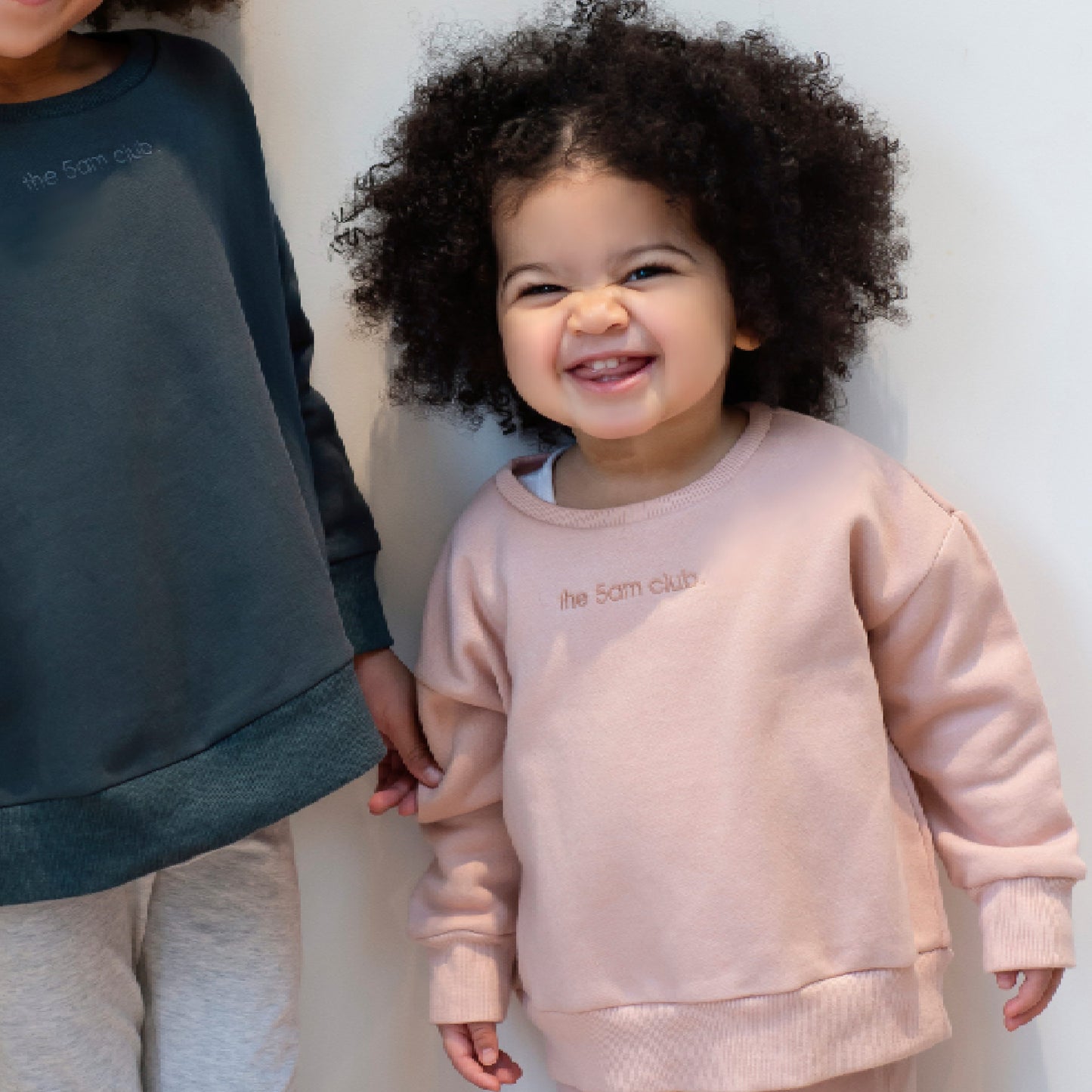 blush pink kids sweatshirt with the 5am club logo on the chest