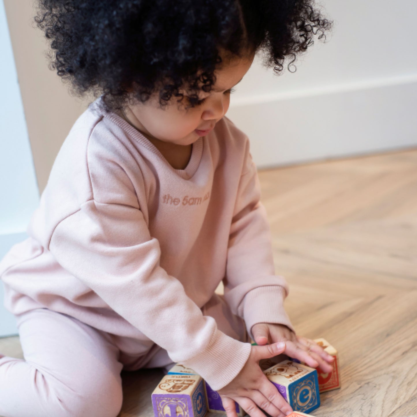 blush pink kids sweatshirt with the 5am club logo on the chest